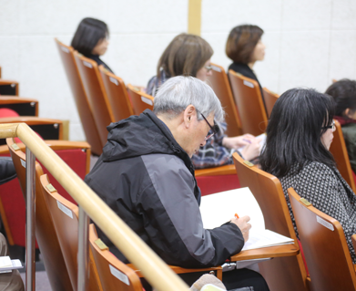 강연에 집중하고 있는 안경 낀 노인의 옆모습