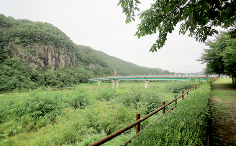 선바위의 웅장한 모습과 이를 이어주는 다리를 담은 풍경 사진.