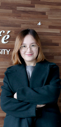 아디바 아르지콜로바 씨가 팔짱을 낀 채 웃으며 포즈를 취하고 있다.