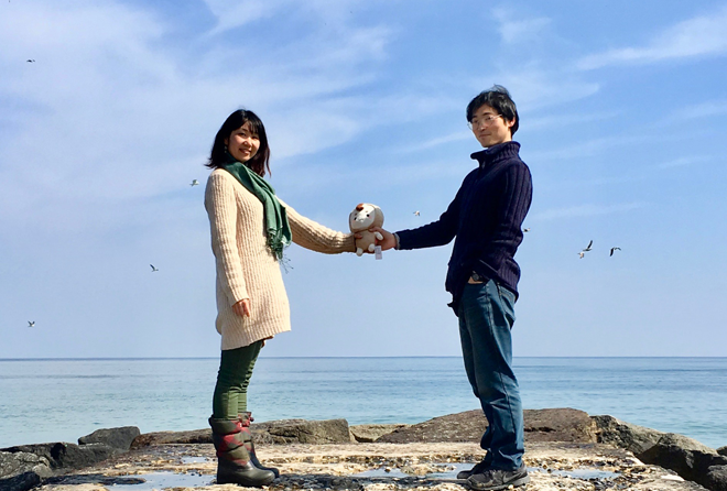 바닷가 바위 위에 마주 선 미노루와 노리코가 한 팔을 뻗어 작은 인형을 같이 쥐고, 시선은 카메라를 바라보고 있다. 