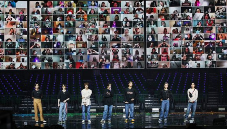 방탄소년단의 온라인 콘서트 모습. 7명의 멤버가 무대 위에 서 있고, 무대 뒤의 초대형 화면 가득 팬들의 모습이 실시간으로 송출된다. 화면은 수십개의 네모로 갈려 팬들의 모습이 송출되고 있다.