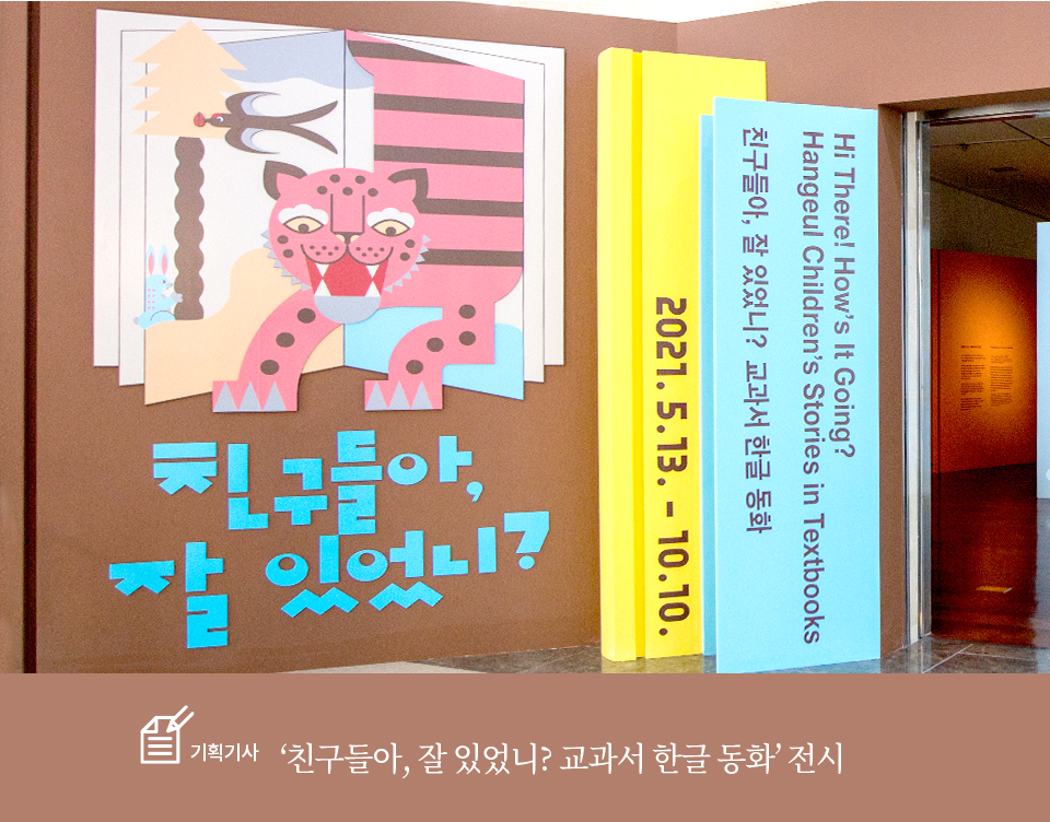 기획기사 ‘친구들아, 잘 있었니? 교과서 한글 동화’ 전시 기사 사진. 전시장 입구 전경. 책장에 책이 꽂혀진 것처럼 꾸며져 있다. 책모양 패널에는 ‘친구들아, 잘 있었니?’, ‘HI, There! How’s It Going? Hangeul Children’s Stories in Testbooks’, ‘2021.5.13. - 10.10.’이 적혀있다. 입구 왼편에는 익살스럽게 생긴 호랑이가 책 속에서 막 뛰어나올 것 같은 그림과 함께 전시 제목 ‘친구들아, 잘 있었니?’가 적혀있다. 입구 너머로 전시장이 보인다.