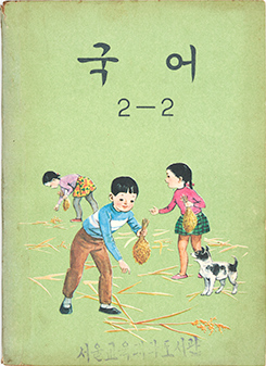 옛 국어 교과서. 연두색 표지에 아이들이 이삭을 줍고 있는 그림이 그려져 있다. ‘국어’, ‘2-2’ 제목이 적혀있으며 하단에 희미하게 ‘서울교육대학도서관’ 도장이 찍혀있다. 책의 모서리는 낡아서 색이 바랬다.