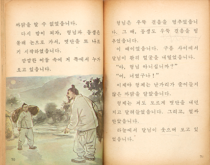 옛 국어 교과서 내용 중 일부. 누렇게 바란 책에는 ‘까닭을 알 수 없었습니다. 다시 밤이 되자, 형님과 동생은 몰래 논으로 가서, 볏단을 또 나르기 시작하였습니다. 깜깜한 어둠 속에 저쪽에서 누가 오고 있습니다.’ 등의 옛이야기가 적혀있다. 이야기 아래에는 한밤중에 흰색 한복을 입고 각자 볏짐을 들고 있는 남성 두 명이 마주 보고 서 있는 그림이 그려져 있다. 