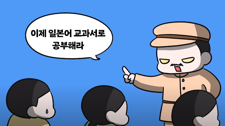 ‘원고로 남은 비운의 사전 말모이, 보물이 되다!’ 만화 영상의 캡처. 아이들을 앞에 두고 일본 순경이 무섭게 눈을 치켜뜨고 있다. 그는 “이제 일본어 교과서로 공부해라”라고 말하고 있다. 