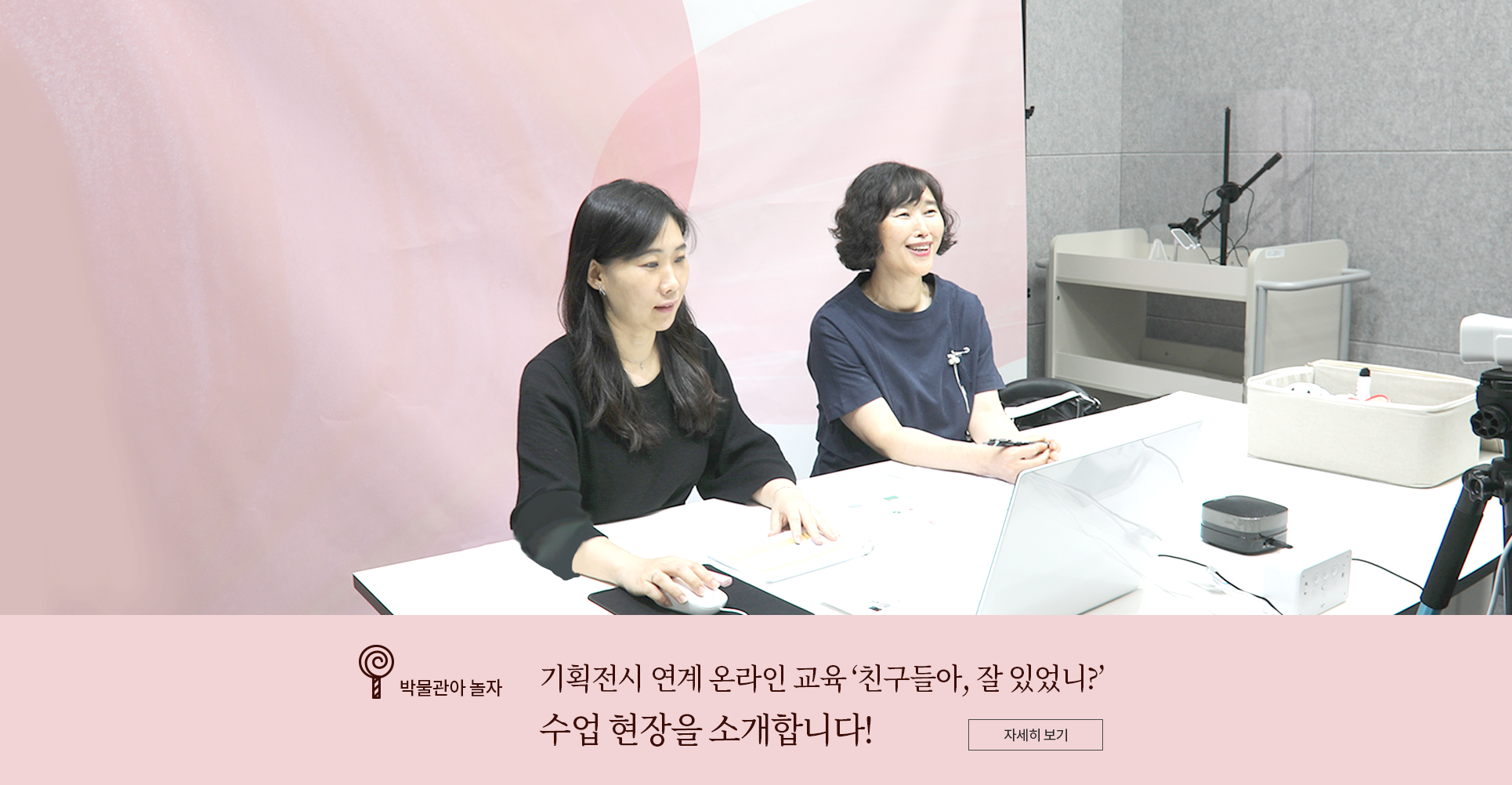 박물관아 놀자 코너 기사 사진. 분홍색 배경을 뒤로 수업을 진행하는 홍유미 강사와 김은실 강사가 나란히 앉아있다. 왼쪽의 홍유미 검은색 원피스를 입고 있으며 가슴께까지 오는 머리를 푸른 채 단정히 귀 뒤로 넘겼다. 홍 강사는 책상 위에 놓인 노트북을 응시하고 있다. 오른쪽의 김은실 강사는 남색 반팔 원피스를 입고 있으며 가슴에는 꽃 브로치를 달았다. 김 강사는 웨이브 진 단발머리이고, 앞쪽을 바라보며 미소짓고 있다. 사진 하단에는 박물관아 놀자 기사 제목인 ‘기획전시 연계 온라인 교육 친구들아, 잘 있었니? 수업 현장을 소개합니다!’가 적혀있다.