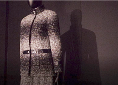 어두운 배경 앞에 세워진 마네킹에 샤넬 한글 재킷이 입혀져 있다. 샤넬 재킷은 흰색과 검은색이 겹쳐져 있다. 