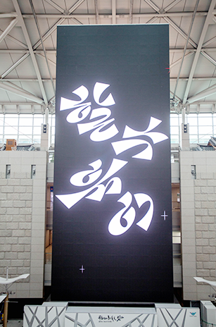 인천공항 내부에 설치된 대형 미디어 타워. 검은색 직사각형 구조물로 ‘할 수 있어’가 캘리그래피로 적혀있다.