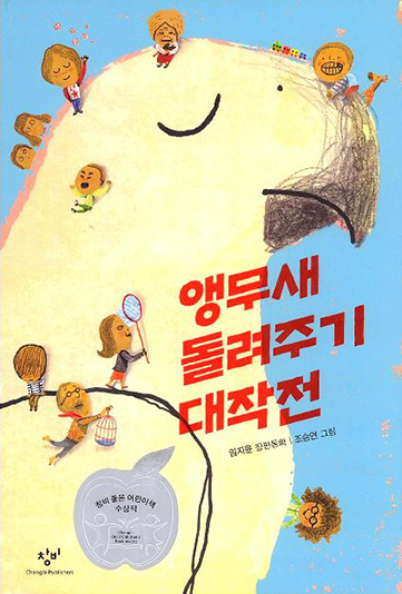 도서 『앵무새 돌려주기 대작전』의 표지. 하늘색 배경에 커다란 앵무새의 옆모습이 그려져 있다. 앵무새는 노란색에 깃털에 짙은 갈색 부리를 가지고 있다. 앵무새는 눈을 감고 있으며 앵무새의 주변으로 작은 사람들이 여기저기 모여있다. 