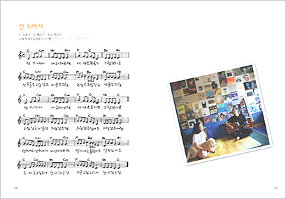 동요 <산 위에서 내려다보면>의 악보이다. 악보 옆에는 기타를 치며 어린이와 함께 노래 부르고 있는 백창우 시인의 사진이 있다.