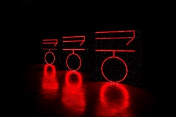 어두운 무대에 붉은색 불빛으로 ‘쿵쿵쿵’이 빛나고 있다. 각 글자 아래에는 붉은빛이 바닥에 비쳐 또다른 원이 있는 것처럼 보인다.