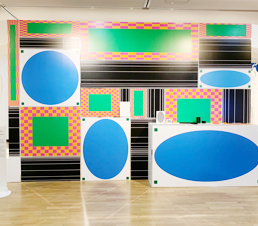 <한글디자인: 형태의 전환> 전시장 일부 모습. 크기가 각각 다른 원형, 사각형으로 이루어진 작품이 벽에 설치됐다. 원은 파란색이며, 사각형은 검은색, 초록색, 빨간색 등으로 표현됐다.