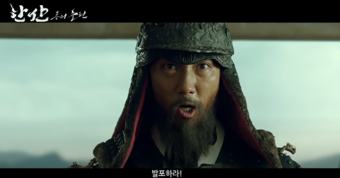 <한산: 용의 출현> 장면 중 일부. 조선시대 갑옷을 입고 수염을 기른 남성이 비장한 표정으로 무언가 말하고 있다.