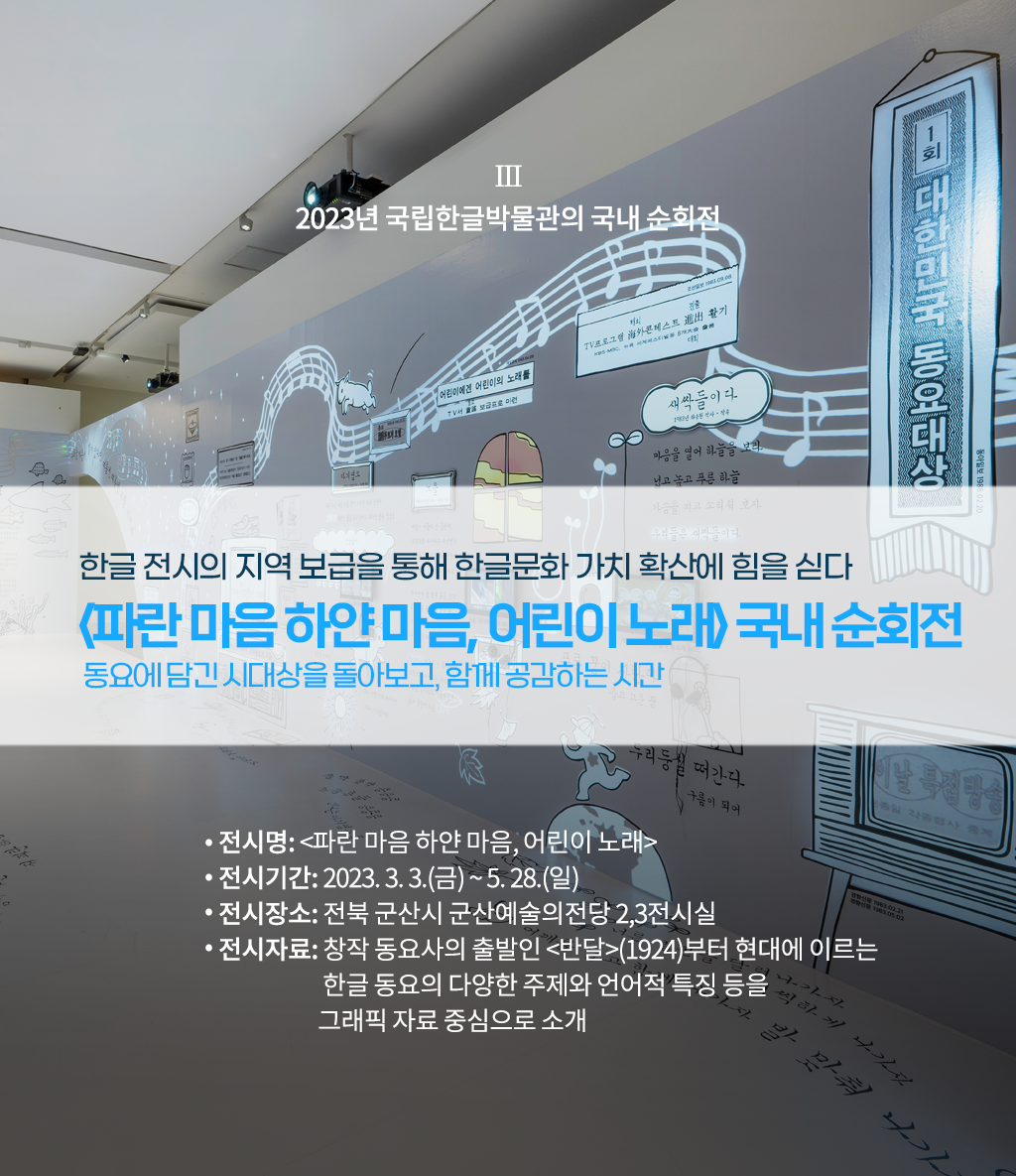 2023년 국립한글박물관의 국내 순회전 설명이다. ‘한글 전시의 지역 보급을 통해 한글문화 가치 확산에 힘을 싣다, 파란마음 하얀마음, 어린이 노래 국내 순회전, 동요에 담긴 시대상을 돌아보고 함께 공감하는 시간’ 문구가 적혀있다. 하단에는 ‘전시명: 파란마음 하얀마음, 어린이 노래, 전시기간:2023.3.3(금)~5.28(일), 전시장소: 전북 군산시 군산예술의전당 2, 3전시실, 전시자료: 창작 동요사의 출발인 반달(1924)부터 현대에 이르는 한글 동요의 다양한 주제와 언어적 특징을 그래픽 자료 중심으로 소개’ 문구가 적혀있다. 배경으로는 전시장의 전경 사진이 사용됐다. 하얀 전시장 벽면과 바닥에는 각종 동요 가사가 적혀있고 관련된 그림들이 그려져 있다.