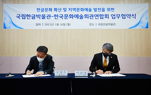 테이블 왼쪽에 앉은 김영수 국립한글박물관장과 오른쪽에 앉은 이승정 한국문화예술회간연합회장이 각자 문서에 서명하고 있다.