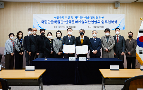 왼쪽에 선 김영수 국립한글박물관장과 오른쪽에 선 이승정 한국문화예술회관연합회장이 문서를 들고, 그 주위로 관계자들이 함께 서 있다. 모두 기념 촬영을 위해 정면의 카메라를 응시하고 있다.