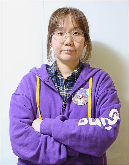 보라색 옷을 입은 에누마코리아 김은파 기획자가 팔짱을 끼고 정면을 바라보고 있다.