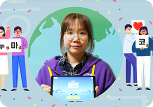 하늘색 배경 안에 지구 모양의 형상이 그려져 있고, 그 안에는 보라색 옷을 입은 에누마코리아의 김은파 기획자가 태블릿을 들고 정면을 바라보고 있다. 양옆엔 에누마코리아와 하트를 든 사람들이 김은파 기획자를 감싸고 있다.