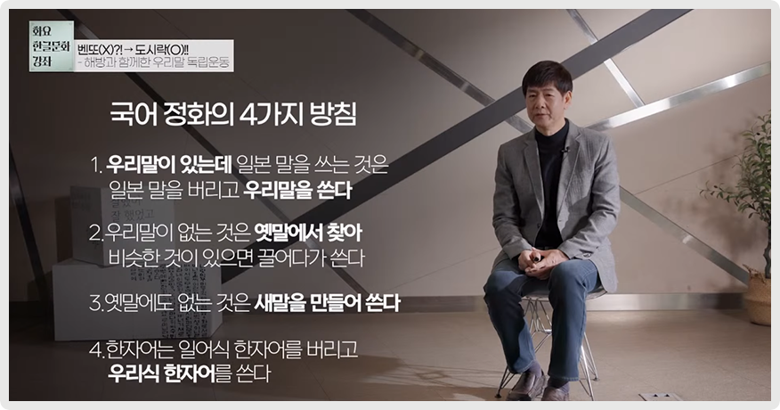 오른쪽에 정재환 책임연구원이 앉아서 이야기하고 있다. 왼쪽엔 ‘국어 정화의 4가지 방침’, ‘1. 우리말이 있는데 일본 말을 쓰는 것은 일본 말을 버리고 우리말을 쓴다’, ‘2. 우리말이 없는 것은 옛말에서 찾아 비슷한 것이 있으면 끌어다가 쓴다’, ‘3. 옛말에도 없는 것은 새말을 만들어 쓴다’, ‘4. 한자어는 일어식 한자어를 버리고 우리식 한자어를 쓴다’라고 적혀있다.