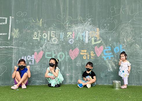 지난 「2022 내가 만난 한글 사진 공모전」 금상 수상작 ‘세상을 맘껏 펼쳐라’ 사진이다. 칠판을 보는 듯한 넓은 벽에 아이들이 다양한 색깔로 이름과 ‘화이팅’ 등을 적었다. 벽 앞엔 네 명의 어린아이가 정면을 바라보고 있다. 