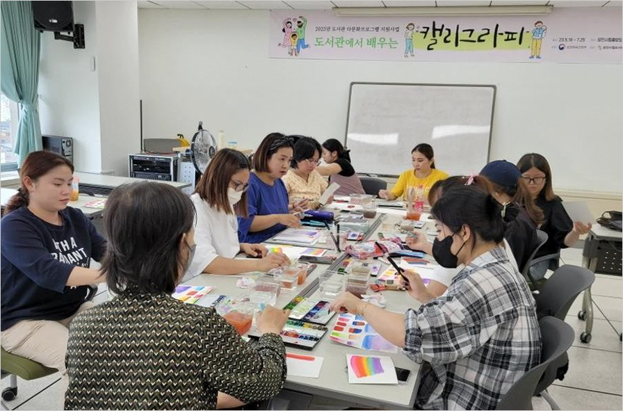 충남 당진시 다문화가족지원센터와 당진시립중앙도서관이 연계해 도서관 연계 체험 중인 베트남 결혼이주여성 자조모임 현장 사진이다. 베트남 결혼이주여성들이 한글 캘리그라피 그리기를 체험하고 있다.