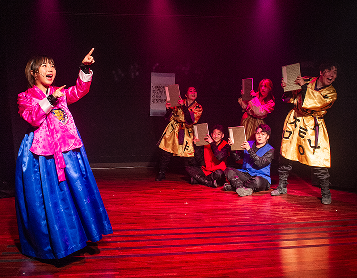 문화행사 기사 사진. 10월 문화가 있는 날 출연단체 극단 가로수포엠의 공연 사진이다. 왼쪽엔 한복을 입은 여성이 양손을 들고 공연하고 있으며, 오른쪽엔 전통 복장을 한 단원들이 각자 책 한권을 들고 공연하고 있다.
