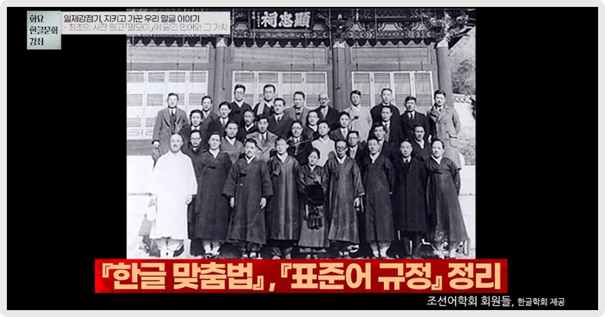 흑백으로 되어 있는 조선어학회 회원들 단체 사진이다. 사진 아래에는 『한글 맞춤법』, 『표준어 규정』 정리라고 적혀있다. 