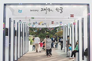 2023년 한글날 기간 국립한글박물관 전경 사진이다. 사람들이 한글 모빌 등 조형물로 꾸며진 통로를 지나가고 있다.