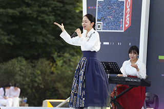 2023년 한글날 기간 국립한글박물관 전경 사진이다. 무대 위에서 흰색 한복을 차려입은 여성이 공연하고 있다.