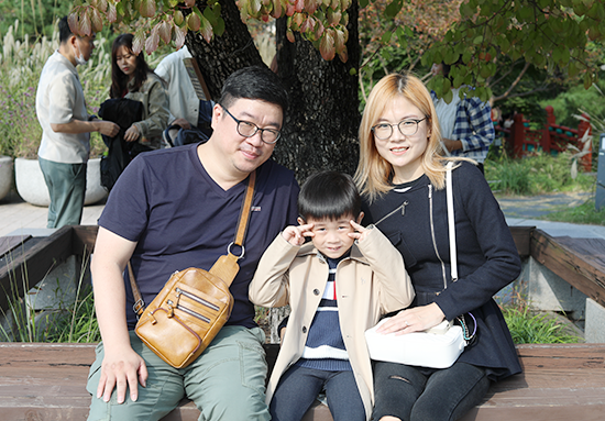 2023년 한글날 국립한글박물관을 찾은 관람객 미니 인터뷰 사진이다. 부부와 남자아이가 카메라를 향해 포즈를 취하고 있다. 