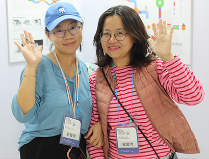 <2023 한글문화산업전시회>의 ‘한글 산업의 장’ 현장 미니 인터뷰 사진이다. 중국인 여성 두 명이 한 손을 들고 카메라를 향해 포즈를 취하고 있다.