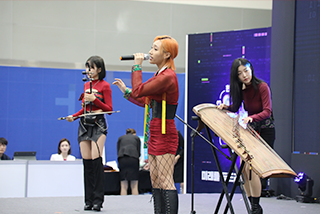 <2023 한글문화산업전시회> 현장 사진이다. 빨간색 의상을 입은 퓨전 국악 밴드 그라나다가 공연하고 있다.