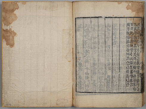 펼쳐진 연갈색의 옛날 책의 오른쪽에 세로로 옛 한글과 한자가 빼곡하게 적혀있다. 왼쪽에는 아무런 글자도 없다.