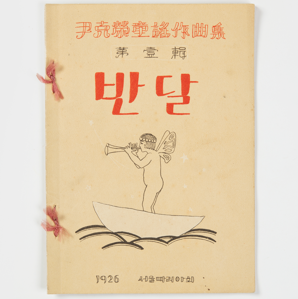 머리에 왕관과 날개를 단 소년이 작은 배를 타고 트럼펫을 불고 있는 그림이 있다. 중앙에 반달이란 글이 쓰여 있다.