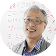 안경을 쓴 이기갑 목포대 교수가 웃고 있고, 그의 뒤에는 빨간색으로 쓰인 글자가 있다.