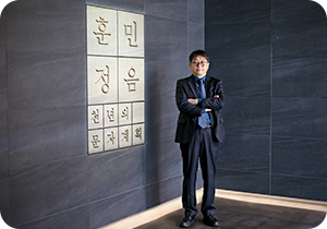 파란색 배경에 동그란 모양이 있고 그 안에 국립한글박물관 전경이 보인다. 
