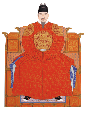 세종대왕이 빨간색 곤룡포를 입고 용상에 앉아 있다.