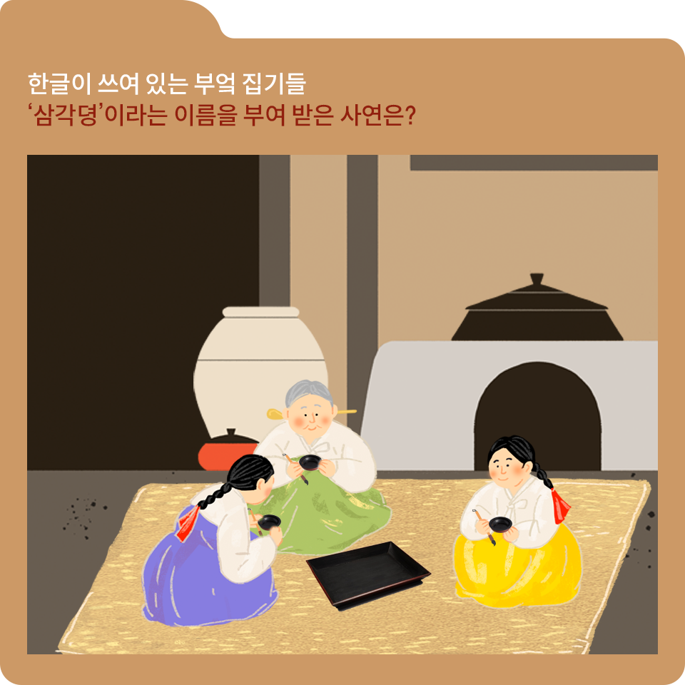 갈색 폴더 그림이 있고, 그림 왼쪽 위에 ‘한글이 쓰여 있는 부엌 집기들 ’삼각뎡‘이라는 이름을 부여 받은 사연은?‘이라고 적혀 있다. 가마솥과 화로, 큰 항아리가 있는 전통 한옥 부엌이 배경이다. 세 명의 여성이 짚으로 엮은 듯한 돗자리에 앉아서 붓을 들고 부엌 집기에 무언가를 쓰고 있다. 왼쪽의 여성은 흰색 저고리에 보라색 한복 치마를 입고 있고, 중앙에 있는 백발의 노인 여성은 연두색 한복 치마를 입고 있다. 오른쪽의 여성은 노란색 한복 치마를 입고 있다. 
