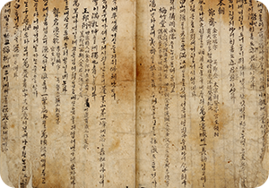 한글로 기록되어 전하는 최초의 노랫말 모음집인 청구영언의 한 페이지가 펼쳐져 있다. 오래된 것으로 보이는 옛 종이에 한자와 한글이 세로로 적혀 있다. 