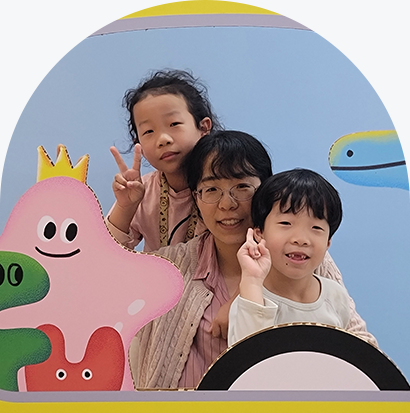 이선화 어머니, 딸 김나은, 아들 김성욱 가족사진이다. 세 사람은 노란색 버스 모양의 포토존에서 사진을 찍었다. 중앙에 안경을 쓴 이선화 씨가 있고, 그 앞뒤로 두 자녀가 서 있다. 두 아이는 모두 손으로 ‘V’자를 만들며 환하게 웃고 있다.