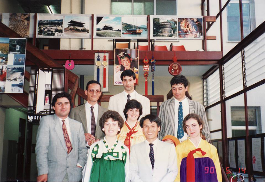 1990년 5월, 신리스본대학교 교내에서 열린 제1회 한국문화주간 때 찍은 사진이다. 젊은 강병구 교수가 중앙에서 환하게 웃고 있고, 그의 주변엔 한복을 입은 외국인 여성 3명과 양복을 입은 외국인 남성 4명이 카메라를 바라보며 미소 짓고 있다.