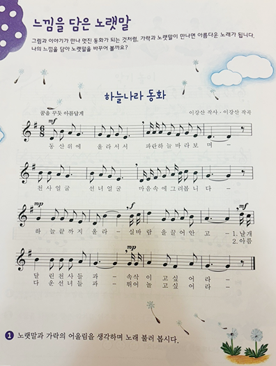 천재교과서 4학년 음악 교과서에 실린 ‘하늘나라 동화’ 사진이다. 교과서 맨 위에는 보라색으로 ‘느낌을 담은 노랫말’이라고 크게 제목이 적혀있다. 그 아래에는 동요 ‘하늘나라 동화’의 악보가 그려져 있다.
