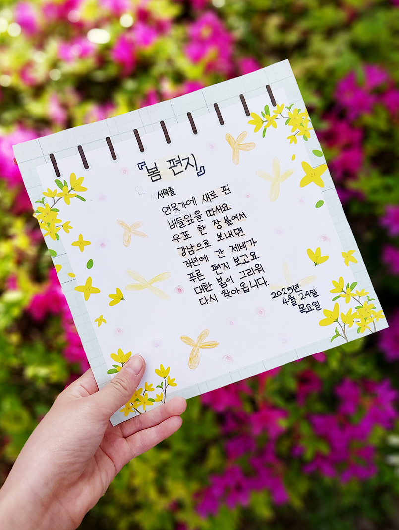 3월 ‘한 글’쓰기 참여작 사진이다. 분홍색 꽃을 배경으로 ‘봄 편지’ 시가 적힌 메모지를 들고 찍은 사진이다. 연못가에 새로 핀 / 버들잎을 따서요 / 우표 한 장 붙여서 / 강남으로 보내면 / 작년에 간 제비가 /푸른 편지 보고요 / 대한 봄이 그리워 / 다시 찾아옵니다