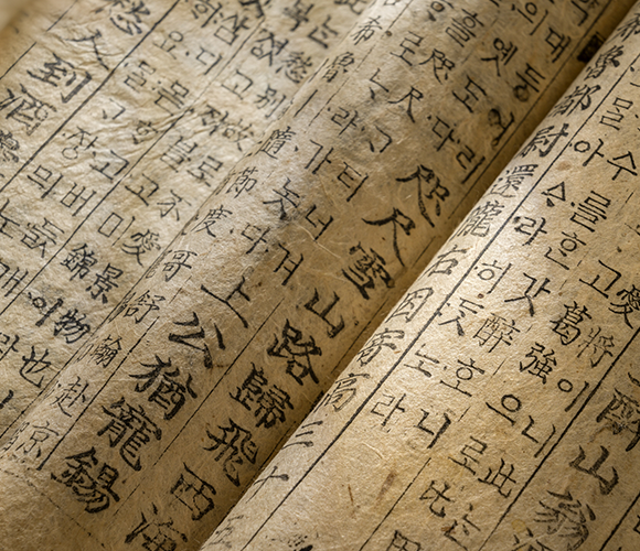 흰색 배경이다. 중앙에는 한글 자음이 색색의 그래픽 이미지로 꾸며져 있다. 글자 하나하나에 다양한 사물이나 장면이 들어 있다. 글자와 그림이 하나로 어우러진 디자인이며, 아래쪽에는 검은색으로 굵게 ‘한글 디자인 공방’이라는 로고가 적혀있다. 로고 왼쪽에는 전통 꽃문양 이미지가, 오른쪽에는 주황색 나비 아이콘이 그려져 있다.