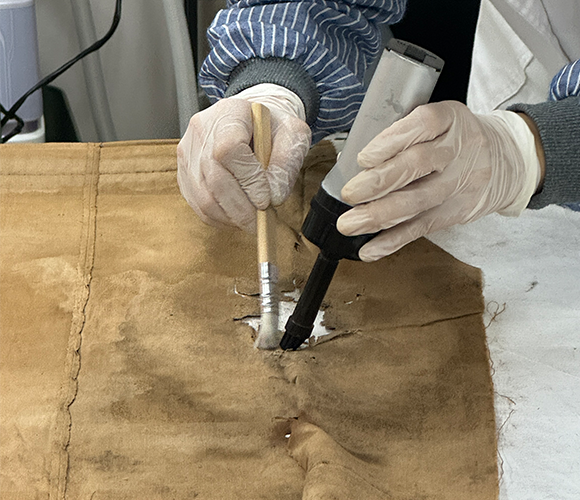 베이지색 배경이다. 중앙에 ‘헌법해의’ 책이 세워져 있고, 그 왼쪽에는 법의 공정함을 상징하는 저울이 있다. 오른쪽에는 목재 판사봉이 받침대 위에 올려져 있다.