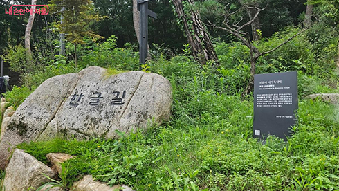 진관사 한글길 사진이다. 산책로 입구로 보이는 곳에 큰 바위가 놓여 있으며, 그 위에 ‘한글길’이라는 글자가 선명하게 새겨져 있다.