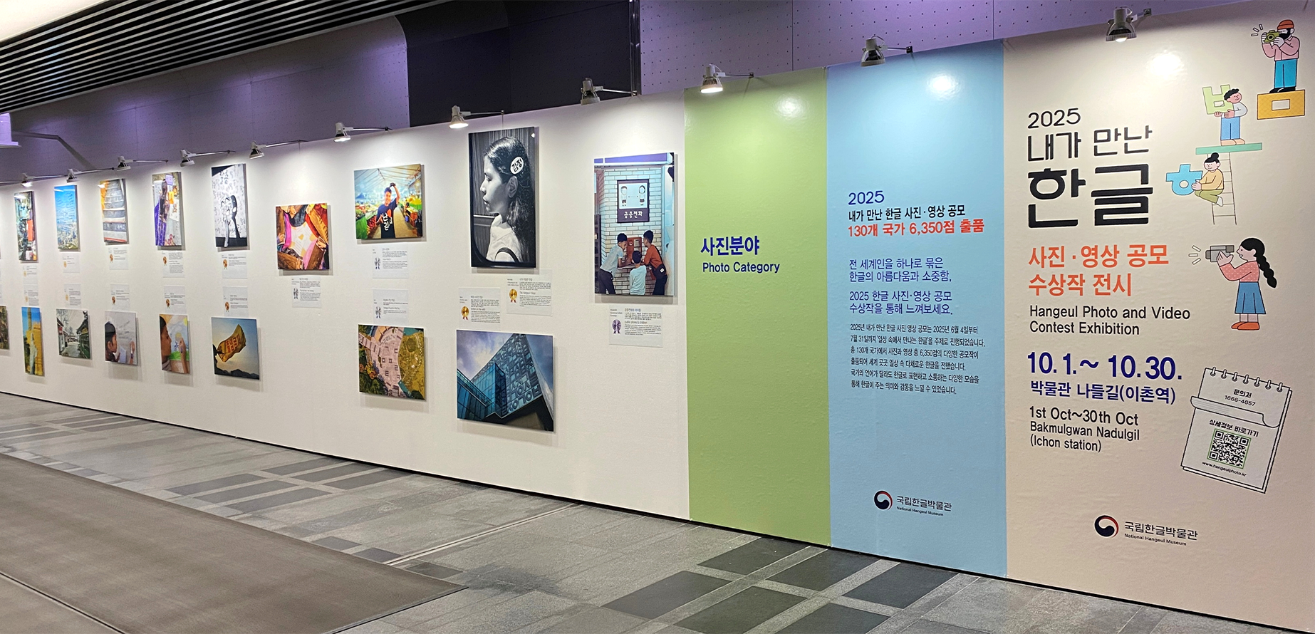 ‘2025년 내가 만난 한글 사진‧영상 공모’ 전시 현장 사진이다. 벽면에는 여러 개의 사진 작품들이 두 줄로 나란히 걸려 있고, 각 사진 아래에는 작품 제목과 설명, 수상 정보가 적힌 안내문이 부착되어 있다.