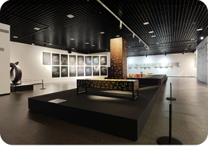 ‘오늘의 한글, 세종의 한글’ 전시장 내부 사진이다. 왼쪽 벽에는 흰색 선으로 한글을 추상적으로 표현한 작품이 여러 개 걸려있다. 중앙에는 한글 자음과 모음이 새겨져 있는 가로로 긴 직사각형 모양과 높고 수직적인 기둥 모양의 조형물 두 개가 놓여 있다. 뒤쪽으로도 한글에서 영감을 받아 탄생한 작품이 여러 개 전시되어 있다.