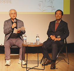 이기갑 명예교수 사진이다. 회색 양복을 입고 안경을 쓴 이기갑 교수가 책을 들고 활짝 웃고 있다.