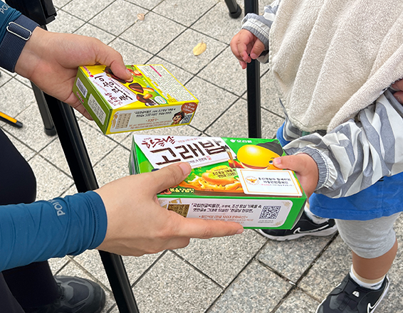 ‘2025 국립한글박물관 한글날 기념 문화행사’에서 경찰관이 행사에 참여한 어린이에게 ‘고래밥’과 ‘초코송이’를 건네고 있다.